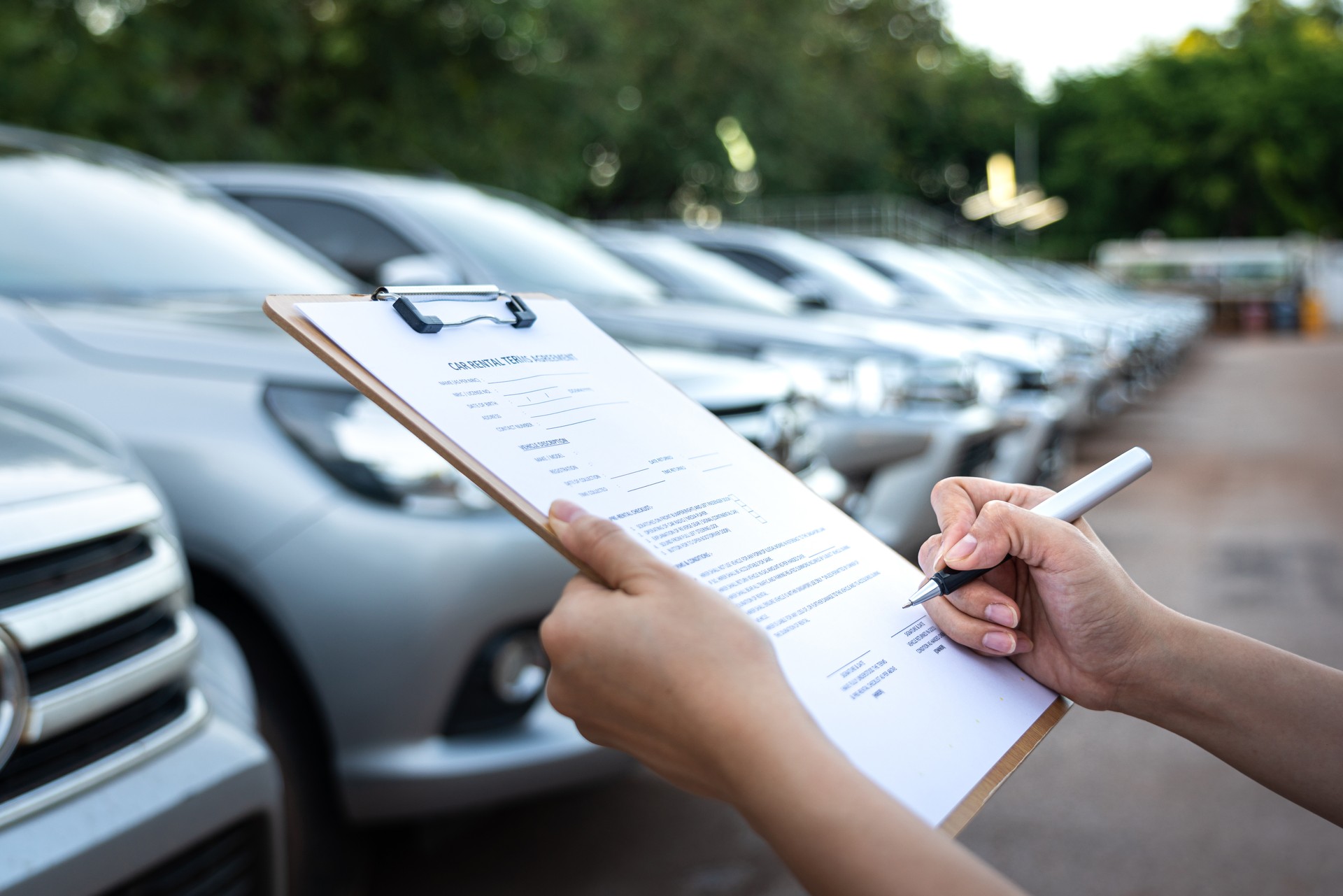 Signing on the agreement term of car rental service - Business and transportation service concept.